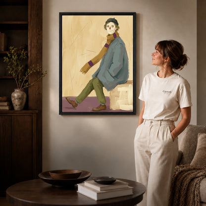 Black framed quiet scarf wanderer artwork beside a woman in a warm neutral living room.