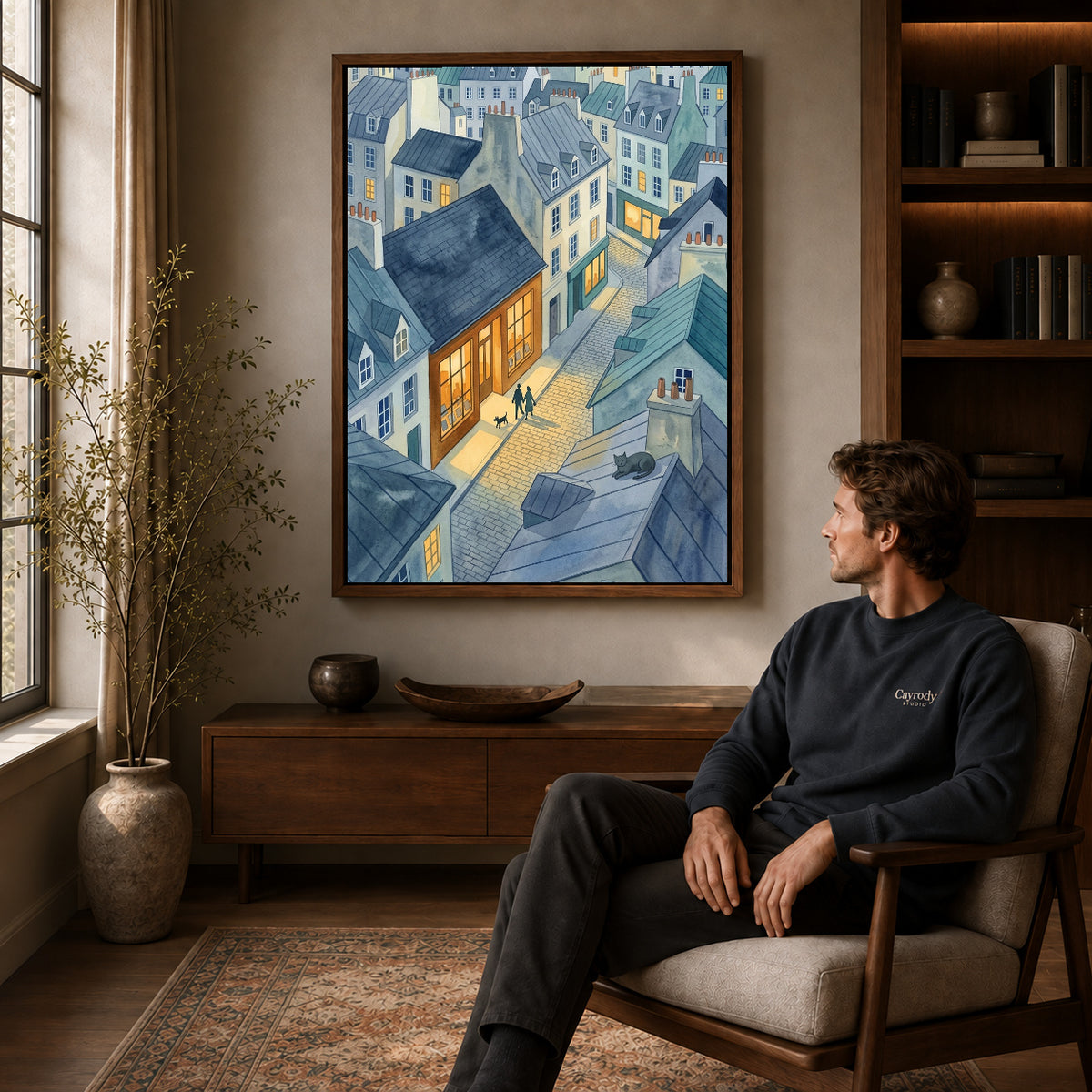 Walnut framed blue rooftop evening artwork above a seated man in a wood furnished living room.