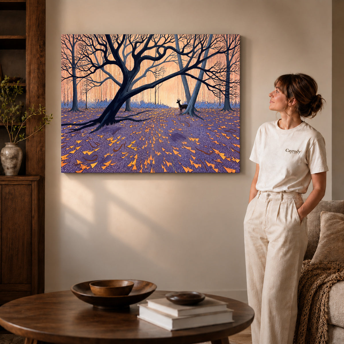 Gallery wrapped twilight forest deer artwork with shaded canvas edges beside a woman wearing cream clothing.