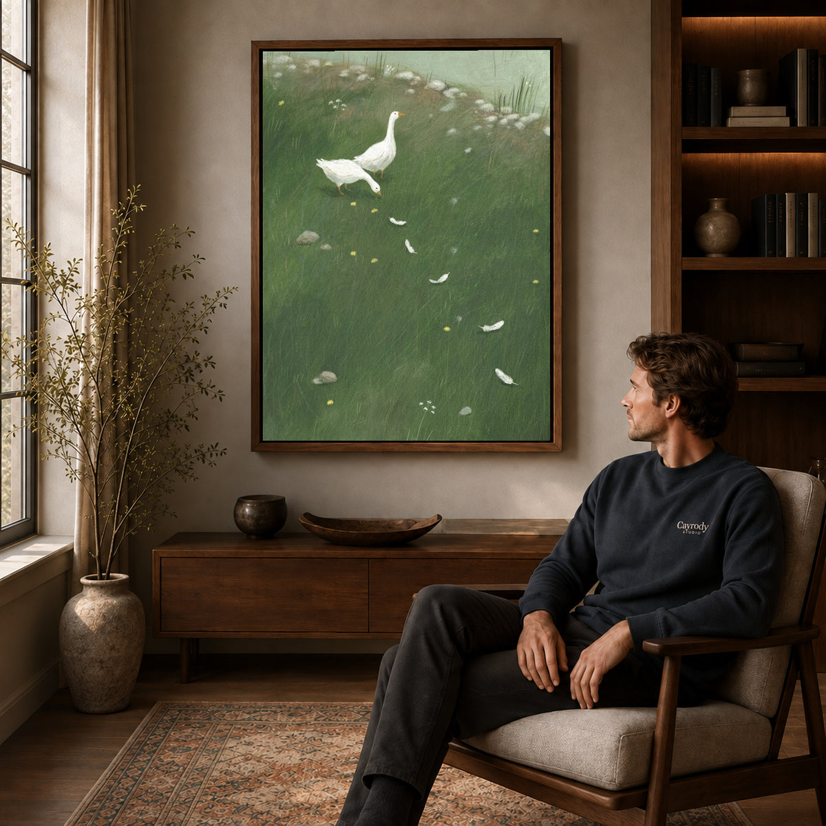 Walnut framed white goose meadow canvas art displayed above a seated man in a wood furnished living room.