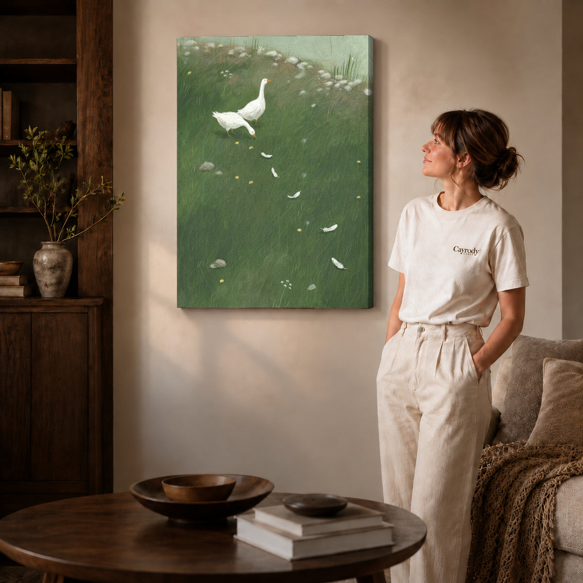 Gallery wrapped white goose meadow canvas art with naturally shaded canvas edges beside a woman wearing cream clothing.