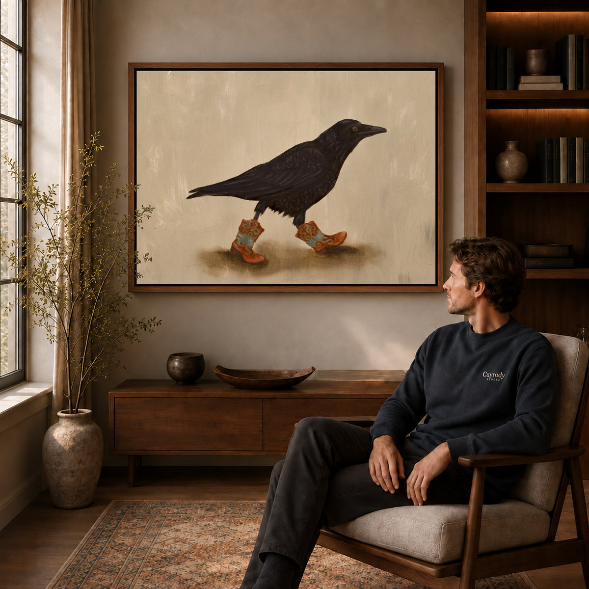 Walnut framed cowboy boot crow artwork above a seated man in a wood furnished living room.