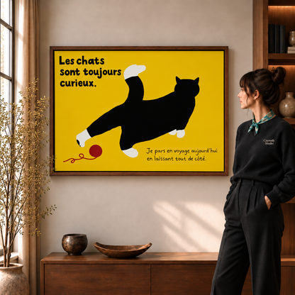 Black cat canvas wall art with French lettering and red yarn beside a woman in a sunlit room.